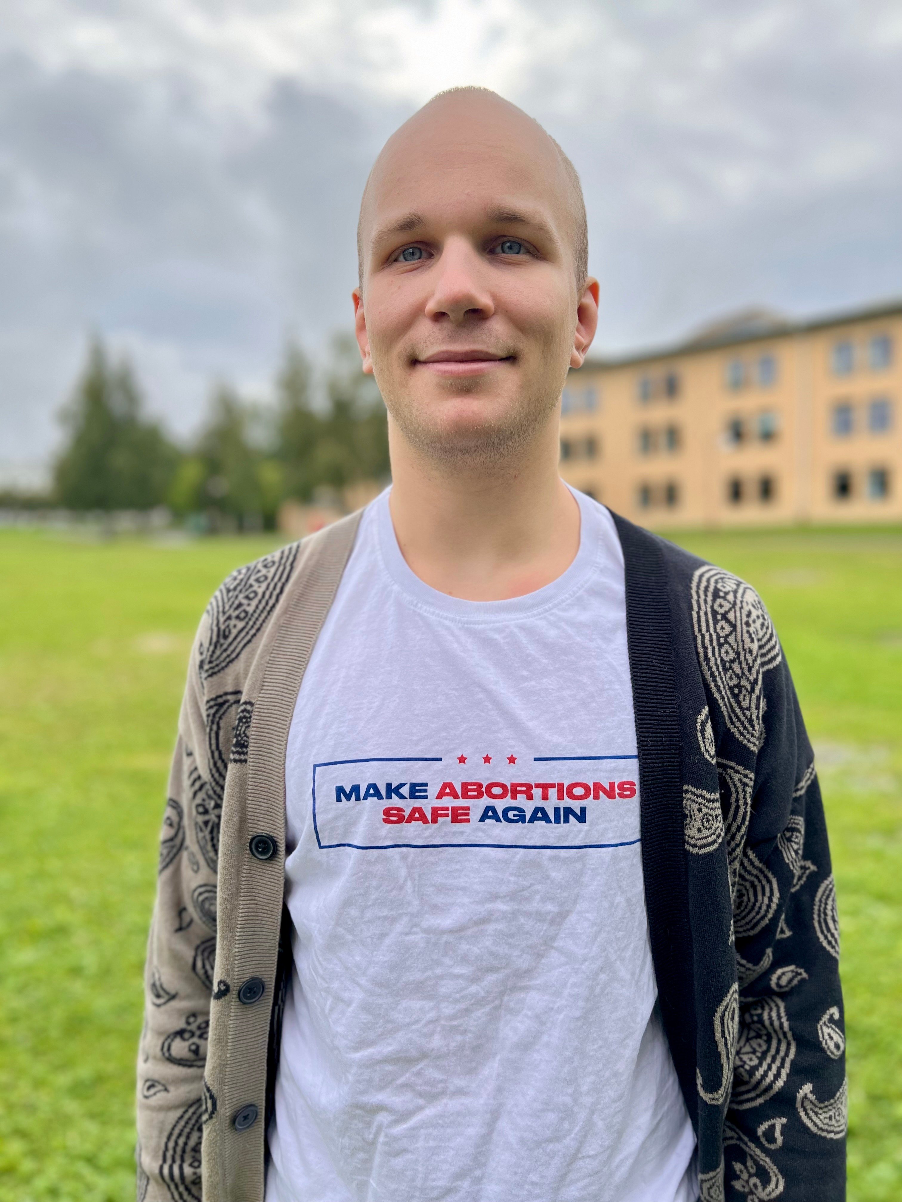 Person med snaggat hår och en t-shirt som det står Make abortions safe again på. 