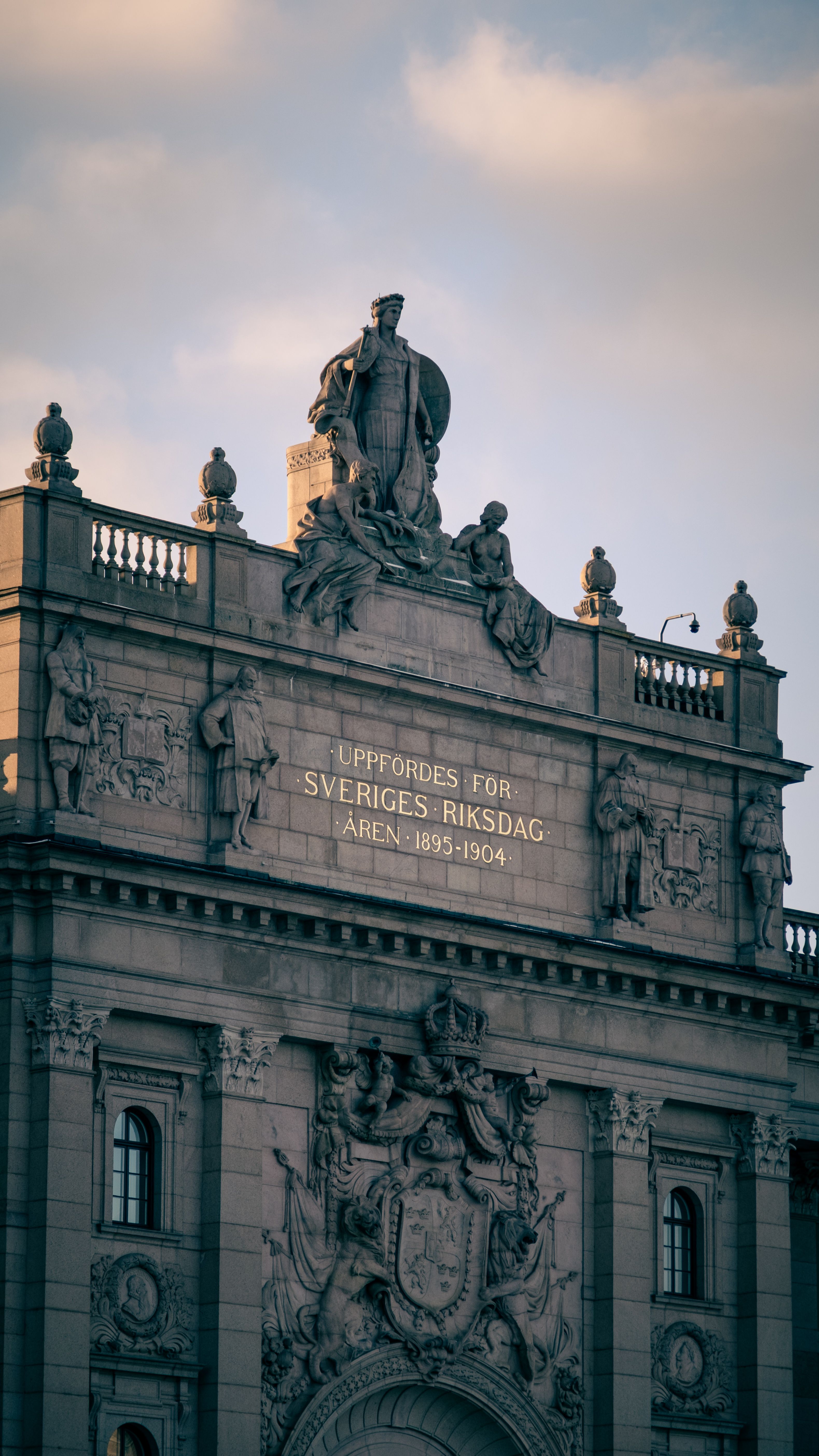 Närbild av den utsmyckade fasaden av Sveriges historiska parlament i Stockholm, tagen under dagen.