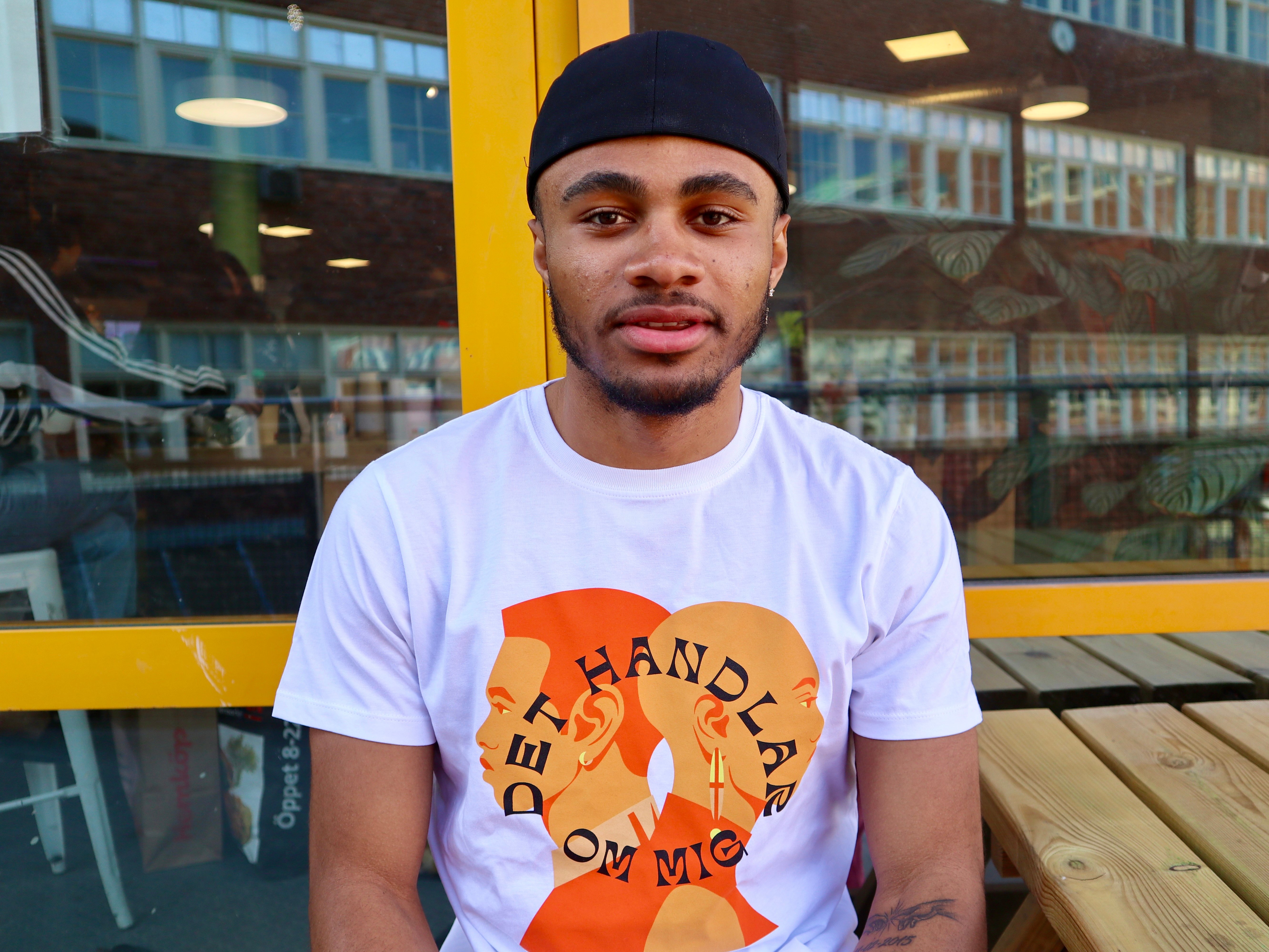 En person i svarta bandana och en t-shirt som det står Det handlar om mig på. 