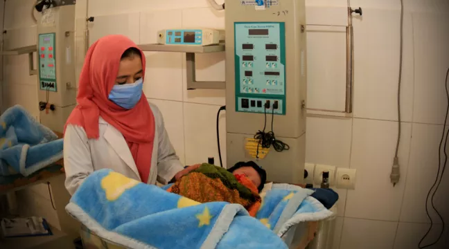 En barnmorska tar hand om ett litet barn på ett sjukhus som Svenska Afghanistankommittén driver i provinsen Wardak, Afghanistan.  