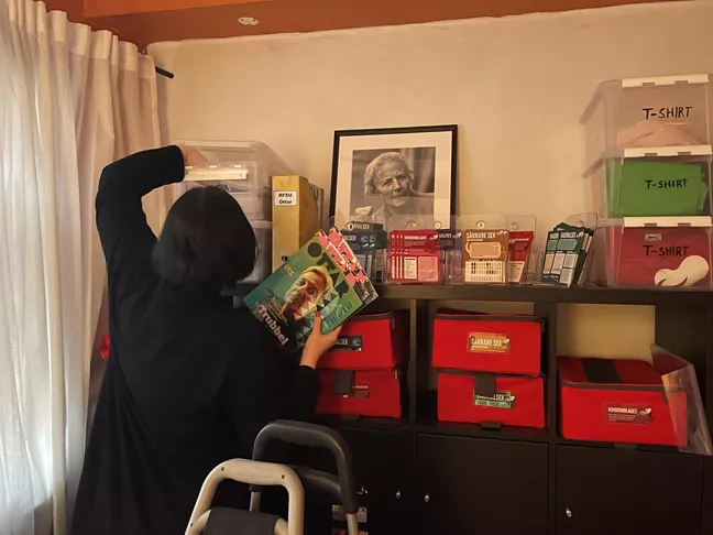 Magdalena plockar ihop saker till goodiebagsen från RFSU Östergötlands fullproppade förråd 