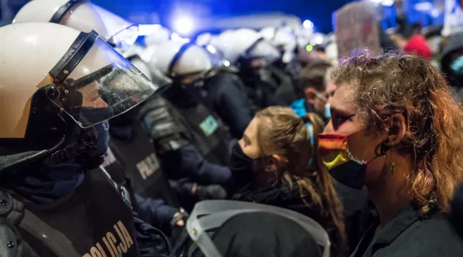 En rad polis står öga mot öga med polska aktivister som demonstrerar för hbtq- och aborträttigheter 