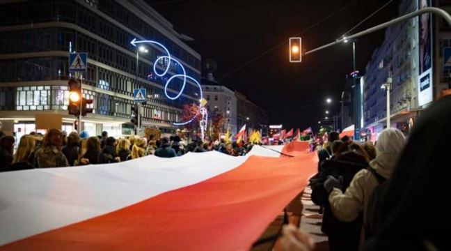 Demonstration mot begränsningar av aborträtten i Polen. Demonstranterna håller i en stor polsk flagga. 