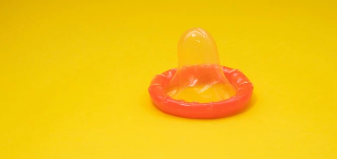 Orangeröd kondom på en gul bakgrund 