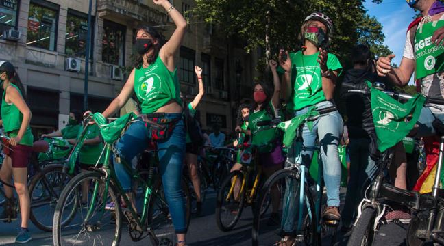 Cyklande demonstranter med gröna tröjor 