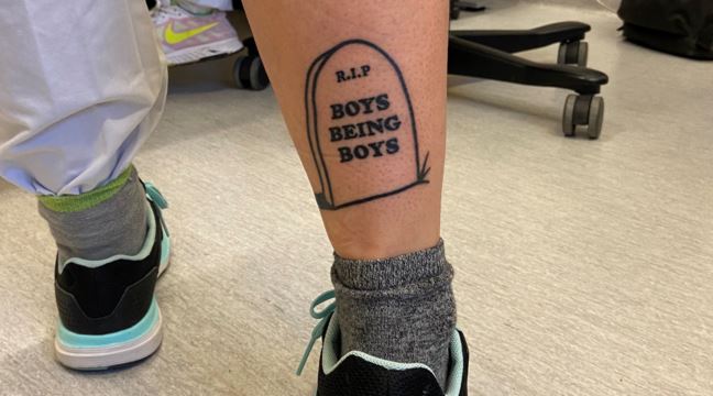 En tatuering där det står RIP Boys will be boys på visas upp på en vad. 