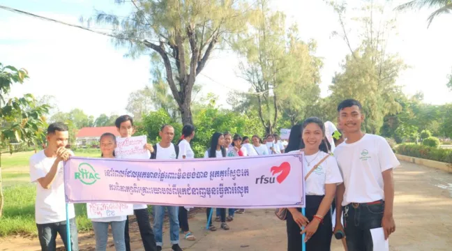 Ett gäng ungdomar bakom en banderoll med RFSU:s logga på. 