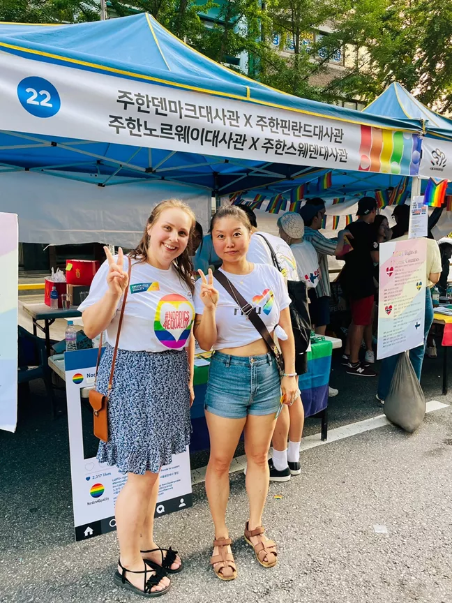 Två glada personer gör v-tecknet. 