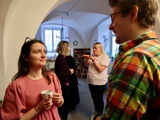 Fyra personer står och pratar med varandra två och två. 