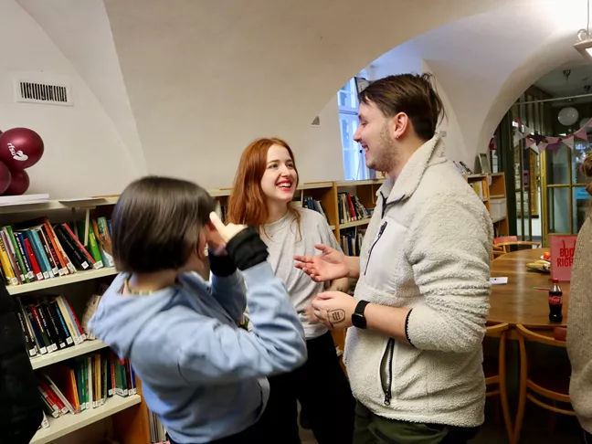 Tre personer pratar och skrattar. 