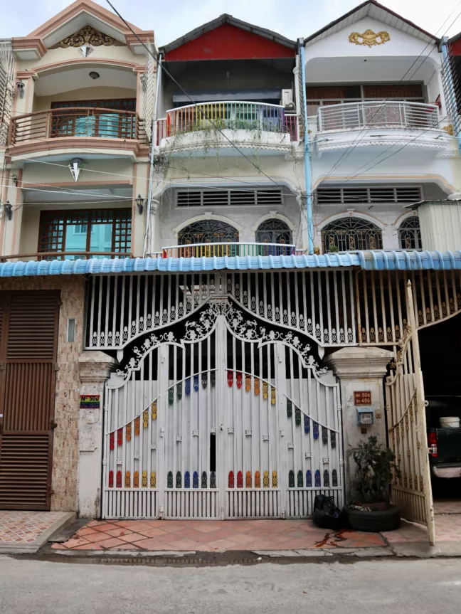 Ett hus i två våningar med regnbågsfärgad balkong. och port 