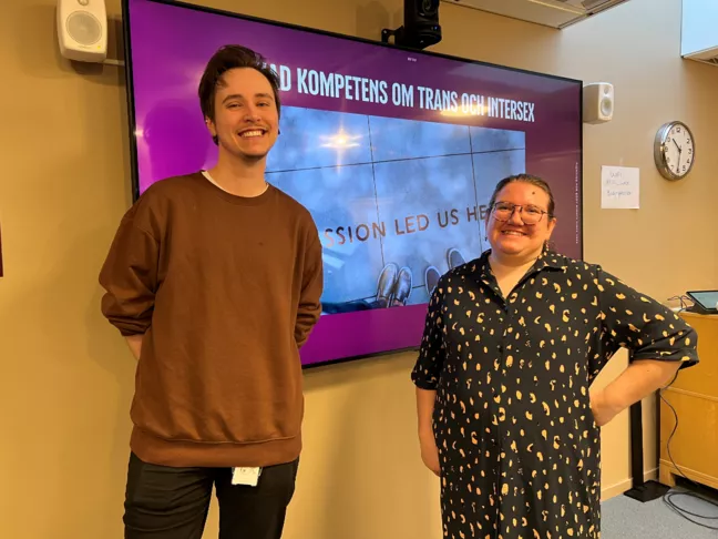 Christoffer och Lo står framför en powerpoint som det står kometens om trans och intersex på. 