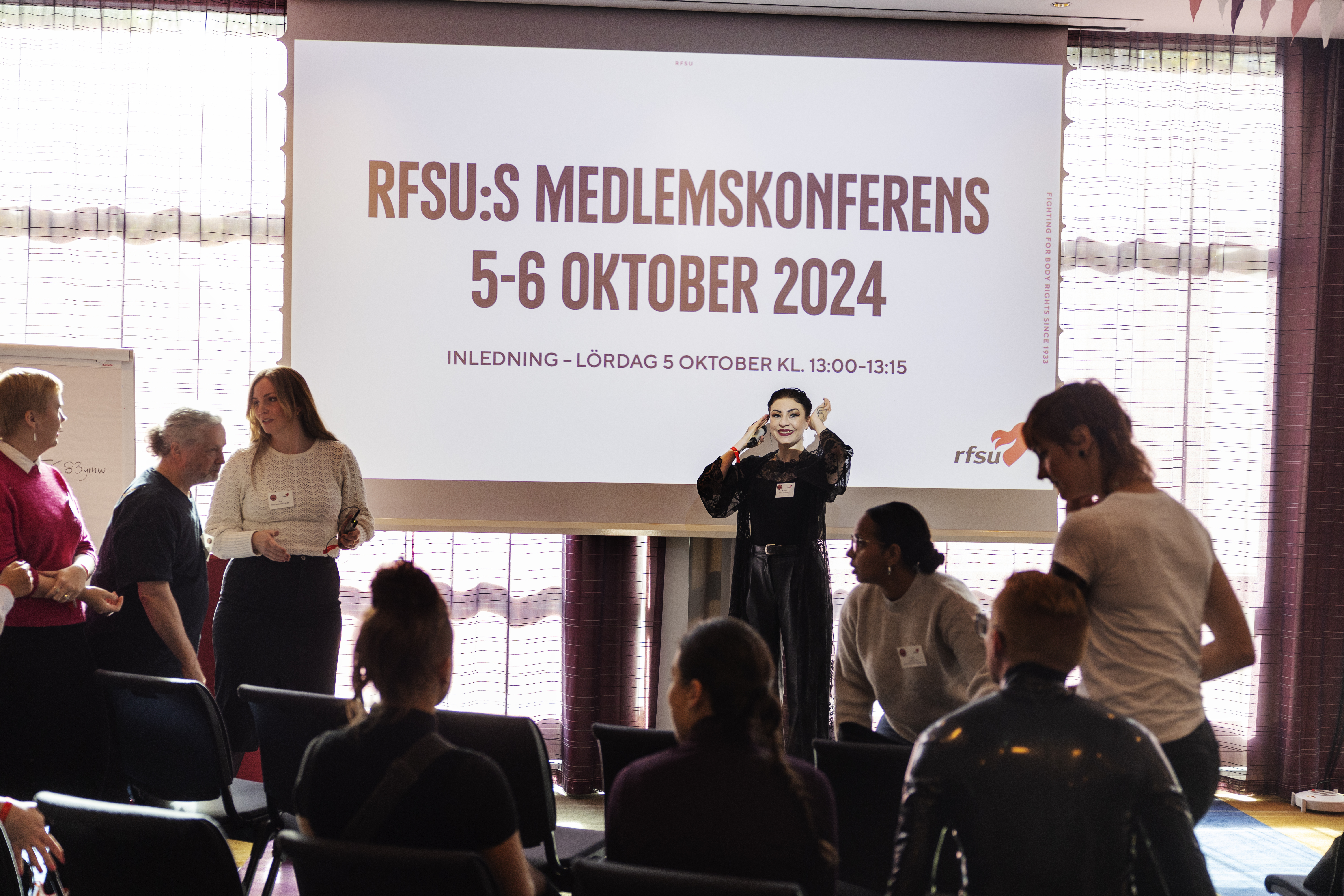 En person gör sig beredd att prata inför RFSU:s medlemskonferens 2024. 