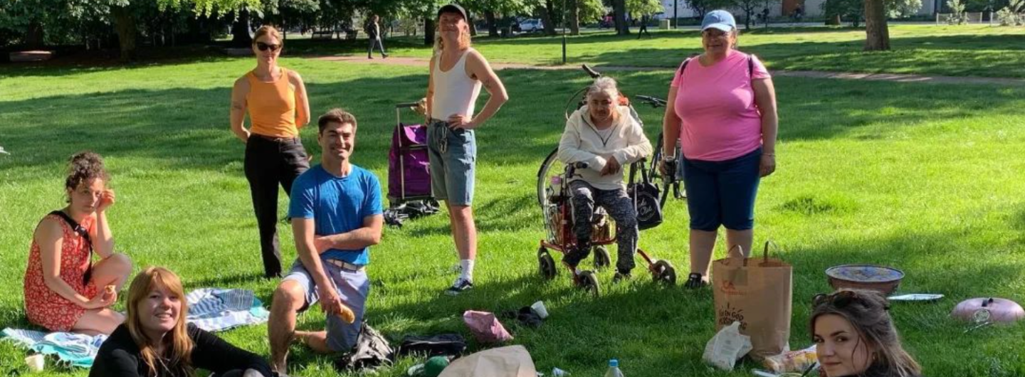 Åtta personer, inklusive personal och deltagare från 'Sex för Alla', har picknick i en park. 