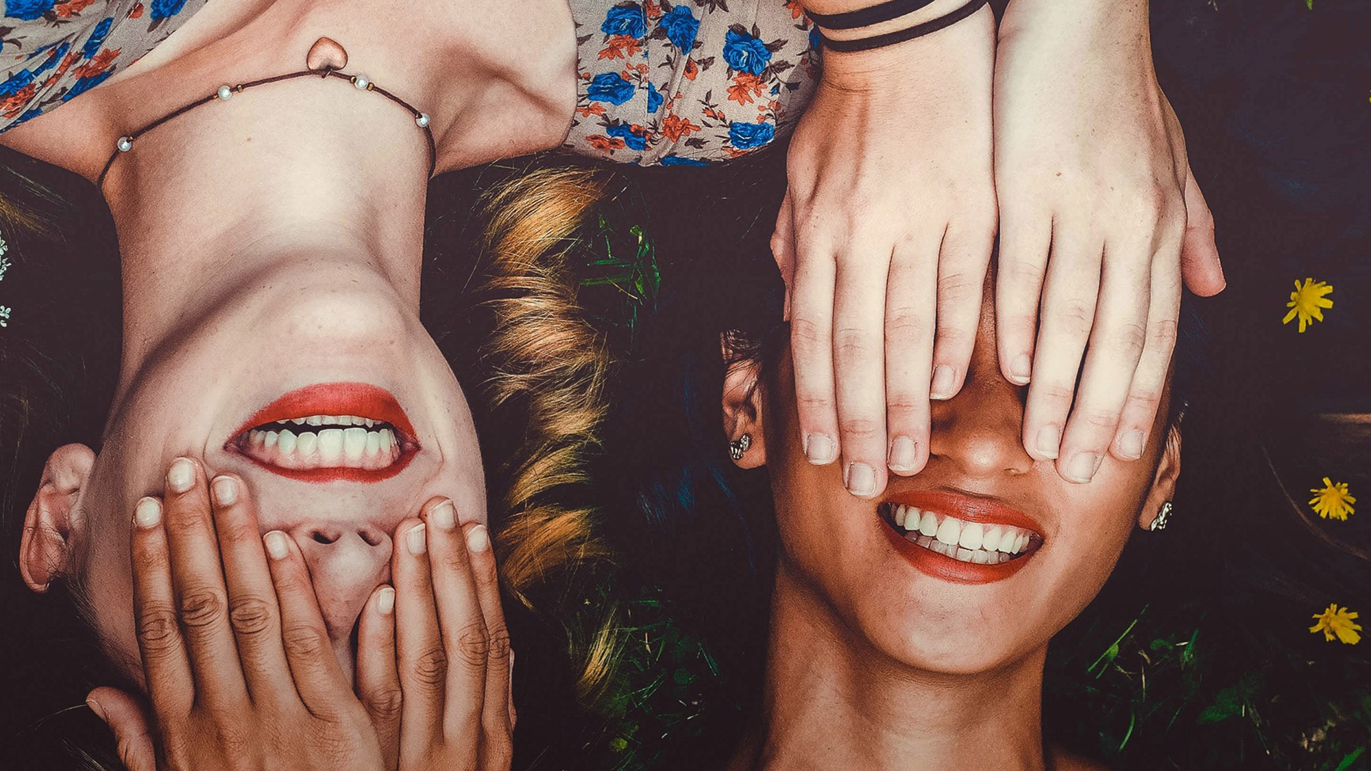 Två unga personer med händer för ögonen 