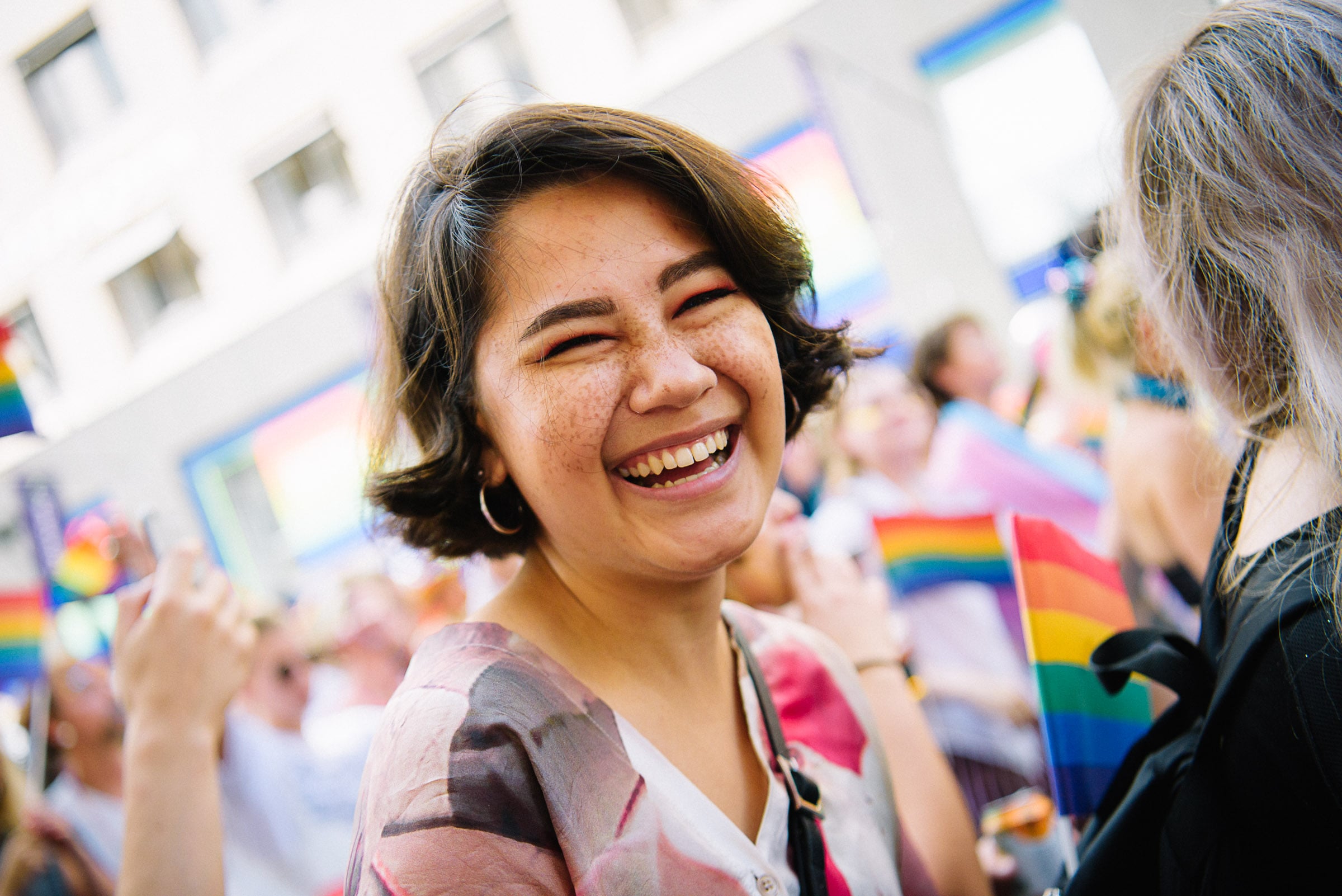 Kvinna ler mot kameran i ett pridefirande.