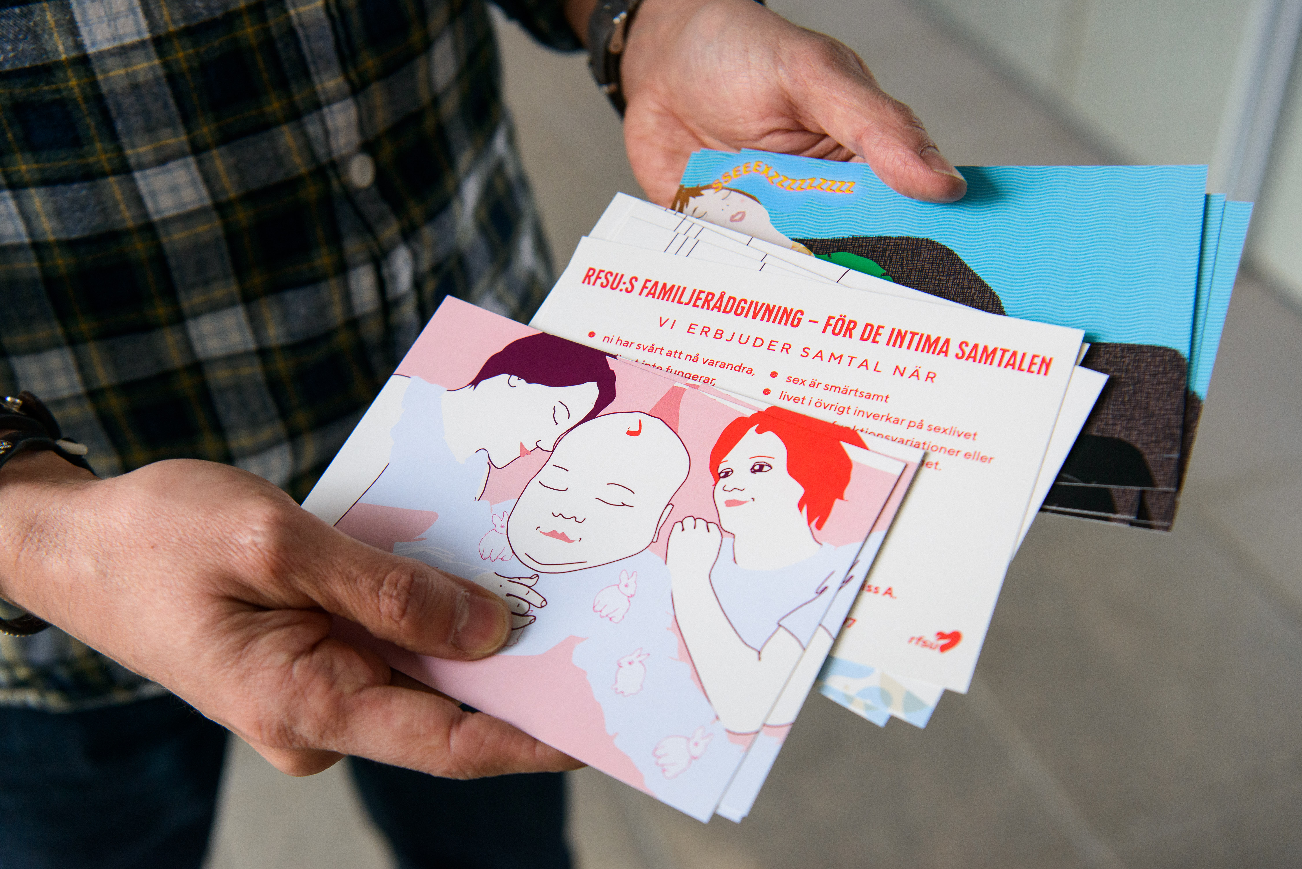 Närbild på händer som håller i informationsbroschyrer