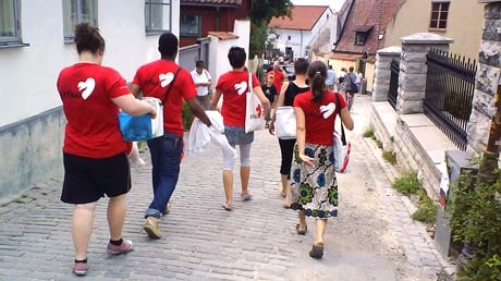 En grupp personer går ner för en backe med röda RFSU t-shirts på.